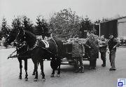 schwarz-weiß Bild, vier Personen vor einer Pferdekutsche mit zwei Pferden