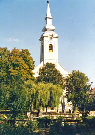 Kirchengebäude von vorne, von Bäumen umgeben