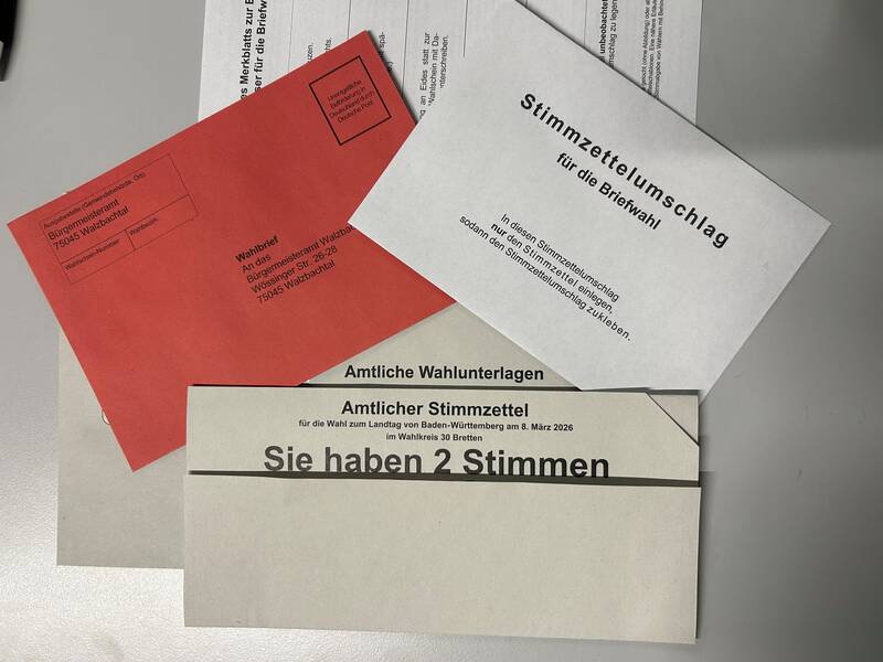 Briefumschläge und Stimmzettel in grau und rot
