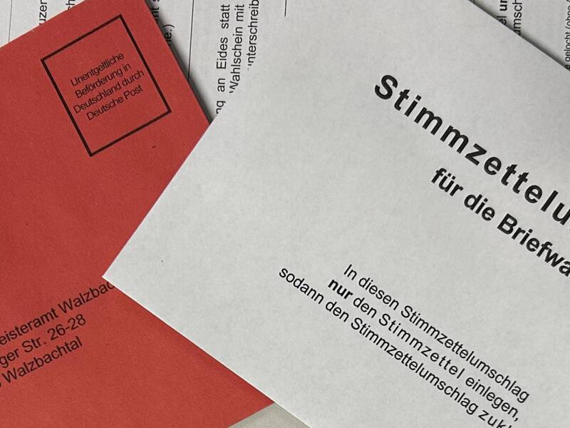Briefumschläge und Stimmzettel in grau und rot