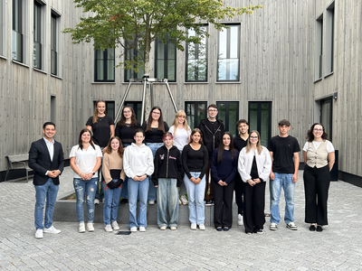Gruppe neuer Auszubildender und Freiwilligen mit Bürgermeister Özcan im Innenhof des Rathauses