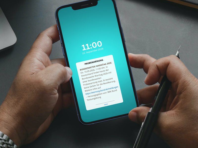 Hände halten Smartphone mit leuchtendem Display in türkis