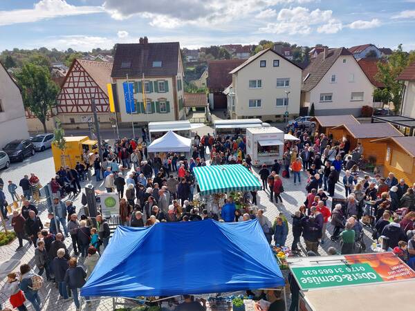 Viele Besucher auf dem Rathausplatz in Wössingen. Es sind verschiedene Stände zu sehen und Pavillions.