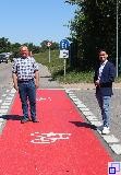 Bürgermeister Özcan und Bauhofleiter Engel stehen auf der neuen Fahrradwegmarkierung