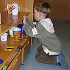 Kind beim Tisch decken